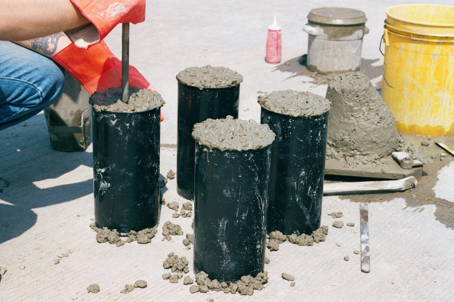 A construction worker is creating concrete samples to test.